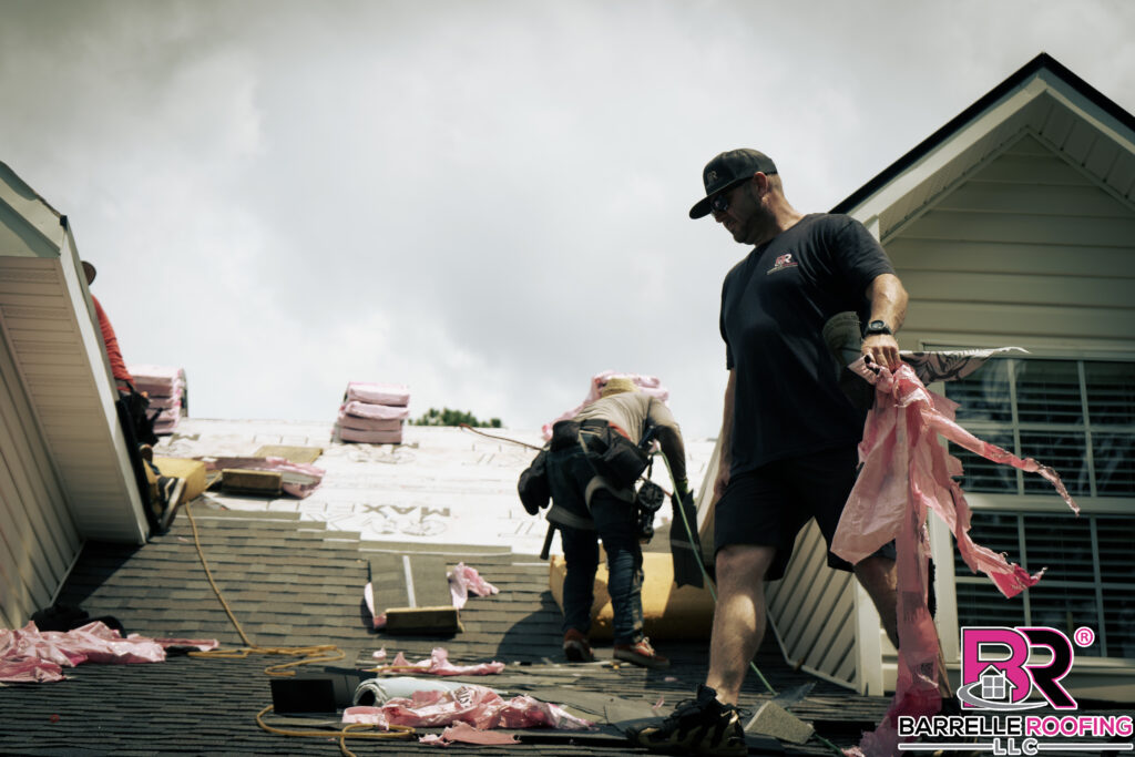 Kevin Barrelle; founder of Barrelle Roofing, walks a roof while picking up debris