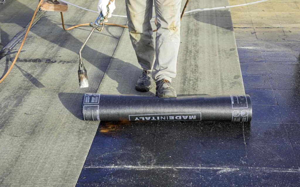 Rolled roofing being applied onto a roof